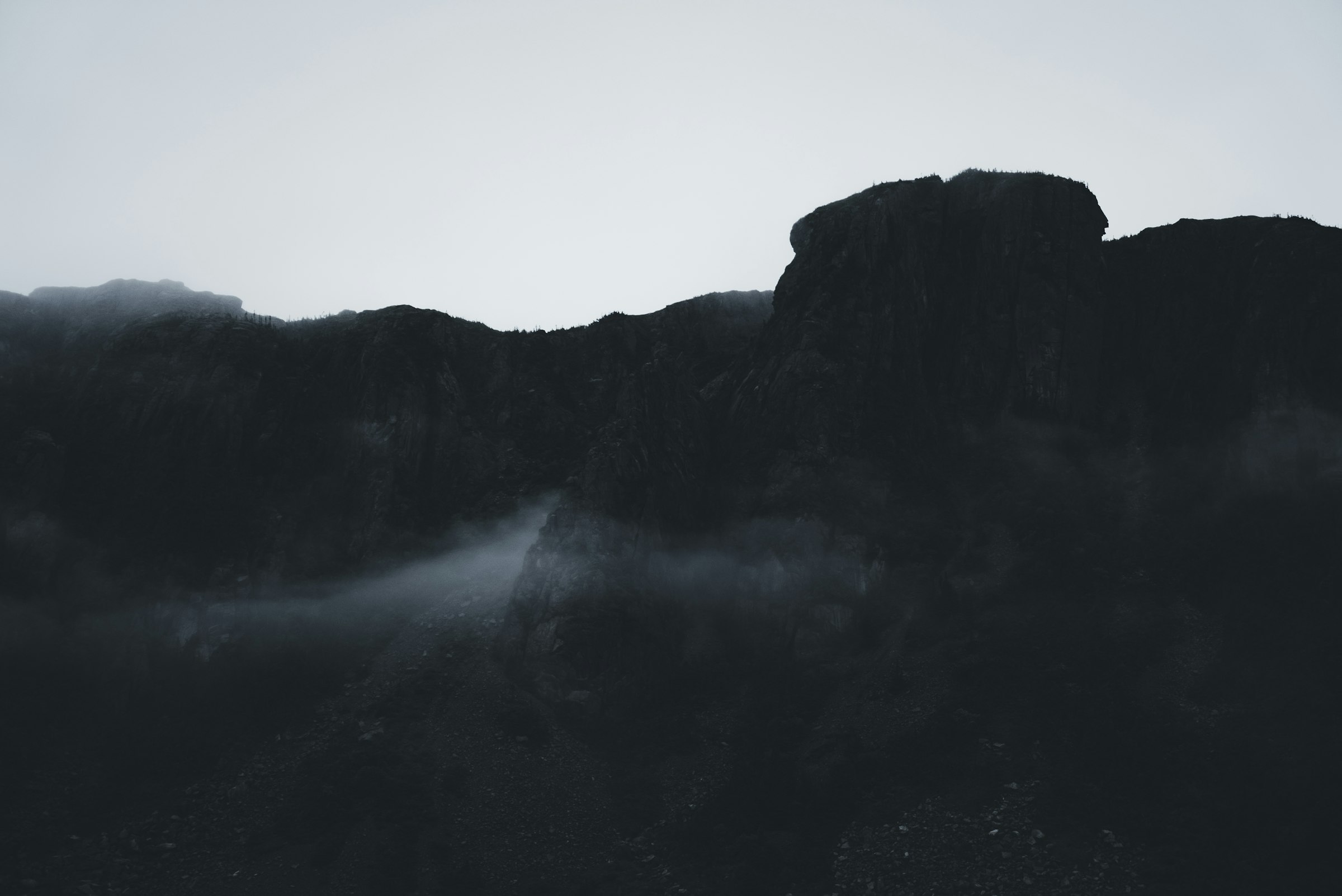 Dark volcanic rock formation with foggy atmosphere
